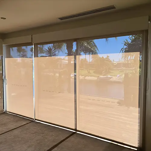 Screen roller blinds fitted across sliding doors in a Gold Coast home