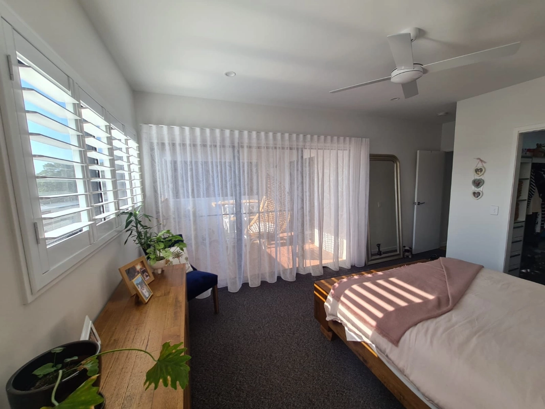 Floor-length sheer curtains softly filtering daylight in a Gold Coast bedroom