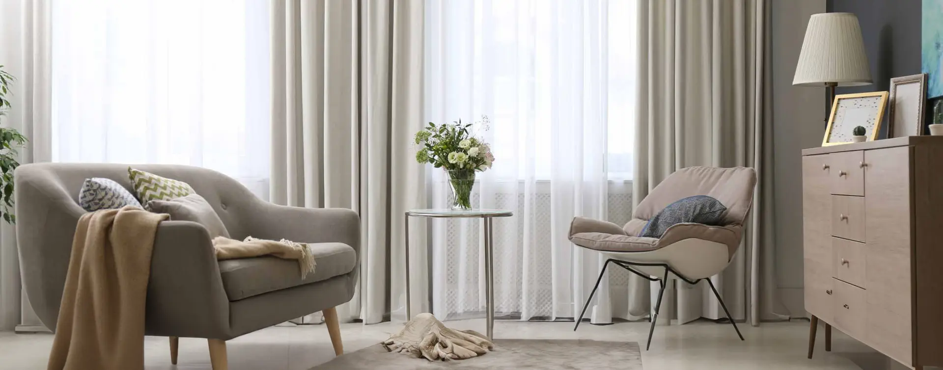 Layered sheer and blockout curtains in a soft neutral living room