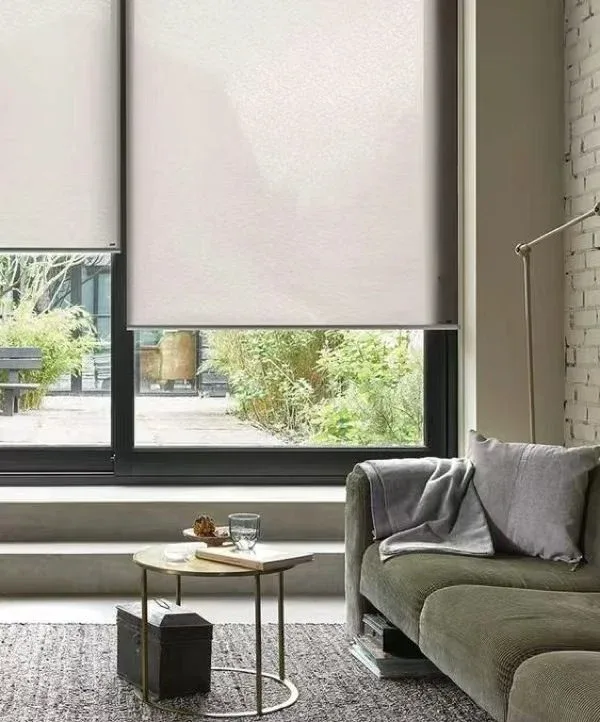 Motorised roller blinds fitted across tall windows in a modern living room