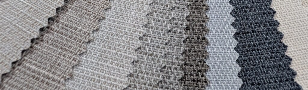 Close-up selection of woven roller blind fabrics in neutral colours