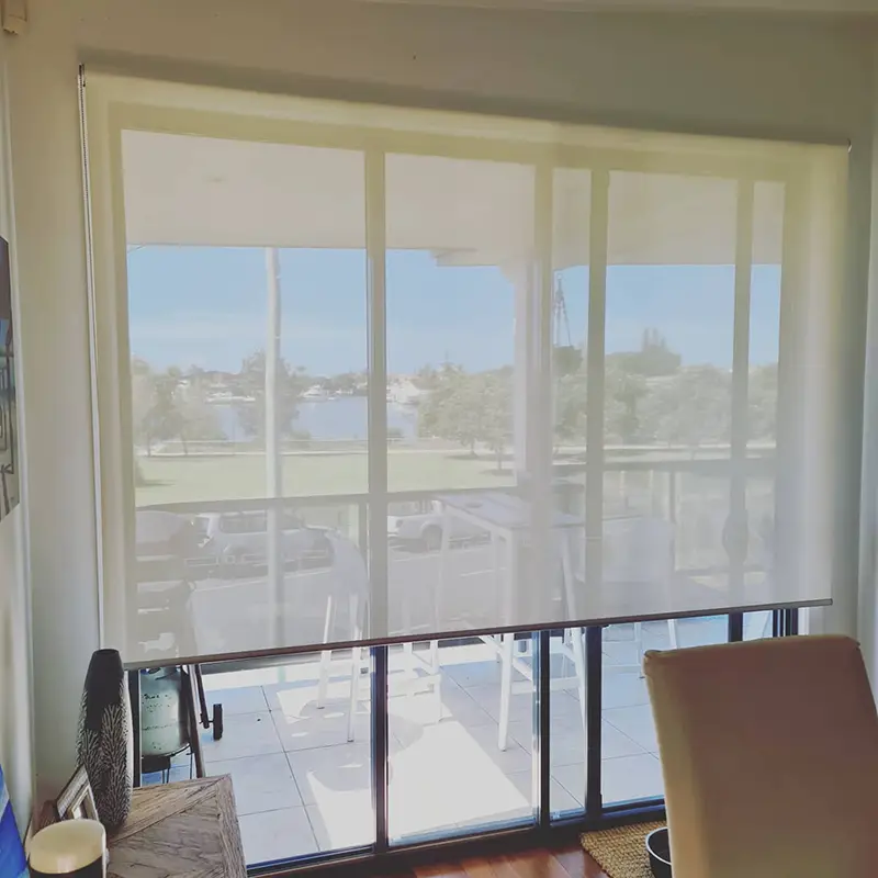 Sunscreen roller blinds on sliding glass doors in a Gold Coast apartment