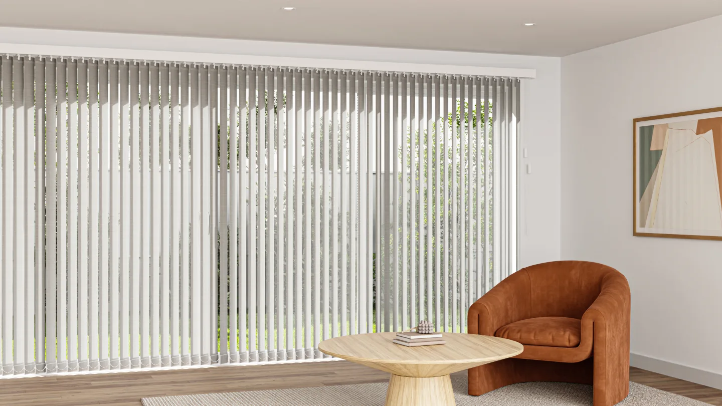 Vertical blinds across large sliding doors in a living room with a tan armchair